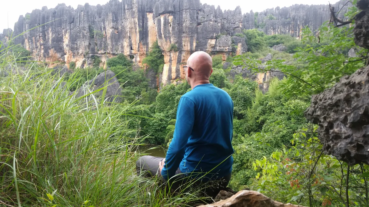 Roeland kijkt uit over een groen karstlandschap in China.